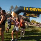 Students run under the New Student balloon arch, 2016.