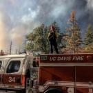 Firefighter stands on top of fire truck