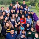 Group of students pose for photo in field.