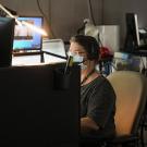 A dispatcher wearing a face covering at her work station