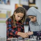 Girls working on science kit. 