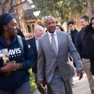 Chancellor Gary S. May flanked by student assistants