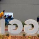 Sign reading "Aggie" with people moving carts in the background.