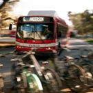 A Unitrans bus drives by rows of parked bicycles.