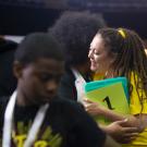 Woman hugs student participant at conference.