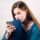 Woman looks at cellphone.