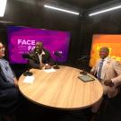 Inside a recording studio, three individuals sit at a round table. From left to right, Stephanie Zarate, Kayton Carter and Chancellor Gary May are seated and laughing in conversation while recording this podcast episode. 