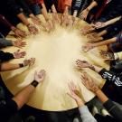 Students put their hands in a circle to show off their henna designs. 