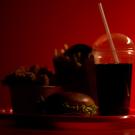 Beverage in plastic up with dark red background. 