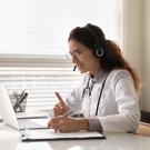 Doctor in a white lab coat looks at a computer. A UC Davis study finds that there were low rates of screening for food insecurity during the pandemic and even lower rates during virtual appointments. (Getty)