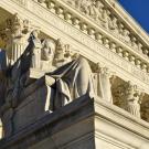 Photo of large government building with statue in front