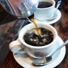 Coffee pours from a carafe into coffee cup