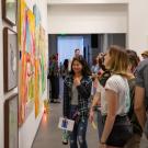 People at museum exhibition with art on walls