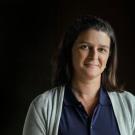 Scientist Tessa Hill in sweater and glasses with black background