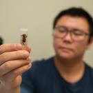 Student holds up a vial with an insect in it