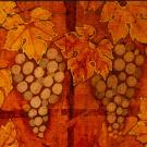 A section of a batik panel depicting maple leaves and bunches of grapes.