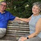 Chuck and Nancy Cooper sit on wood bench