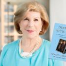 Photo of woman in blue dress holding book