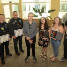 Two fire department personnel and three students flank the man they saved