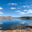 Blue lake with mountains and sky in background