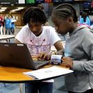 Two girls working at a laptop. 