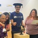 With four family members near him, Tanishq Abraham rings a bell to signify he has earned a doctoral degree.te