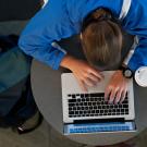 An overhead view of a student working on a laptop