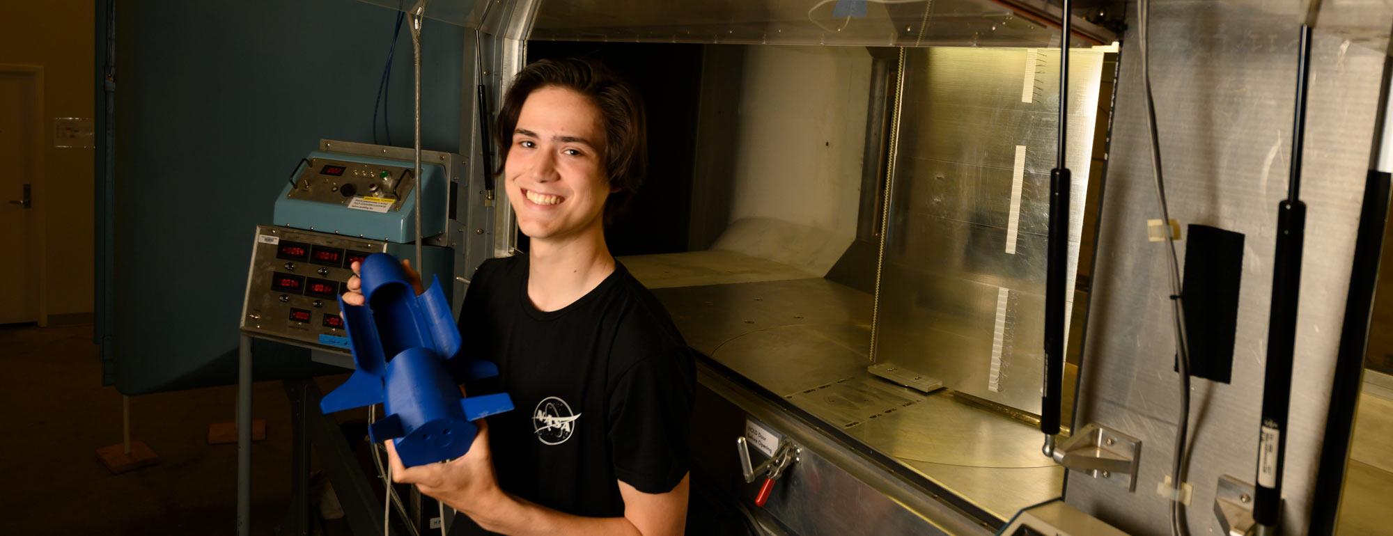 A male student holding a space shuttle model.