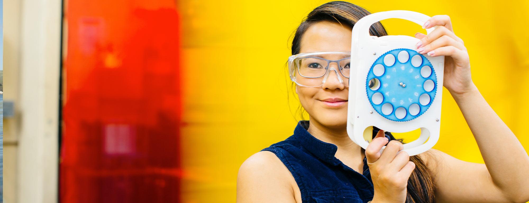 A UC Davis Biomedical Engineering alum poses with here vision improvement invention