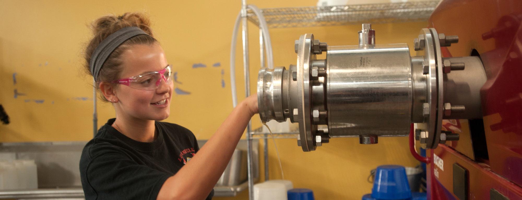 A female student fine tunes some biotech machinery