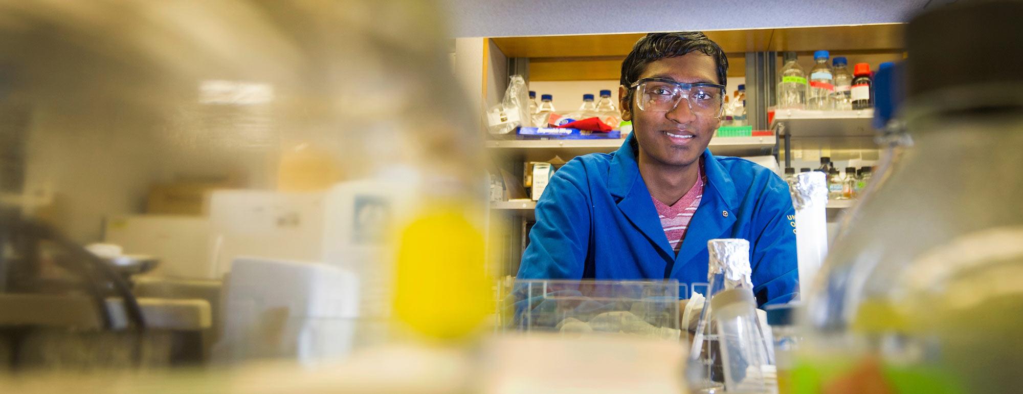 A Cell biology student peeks out from behind the samples he has been working with