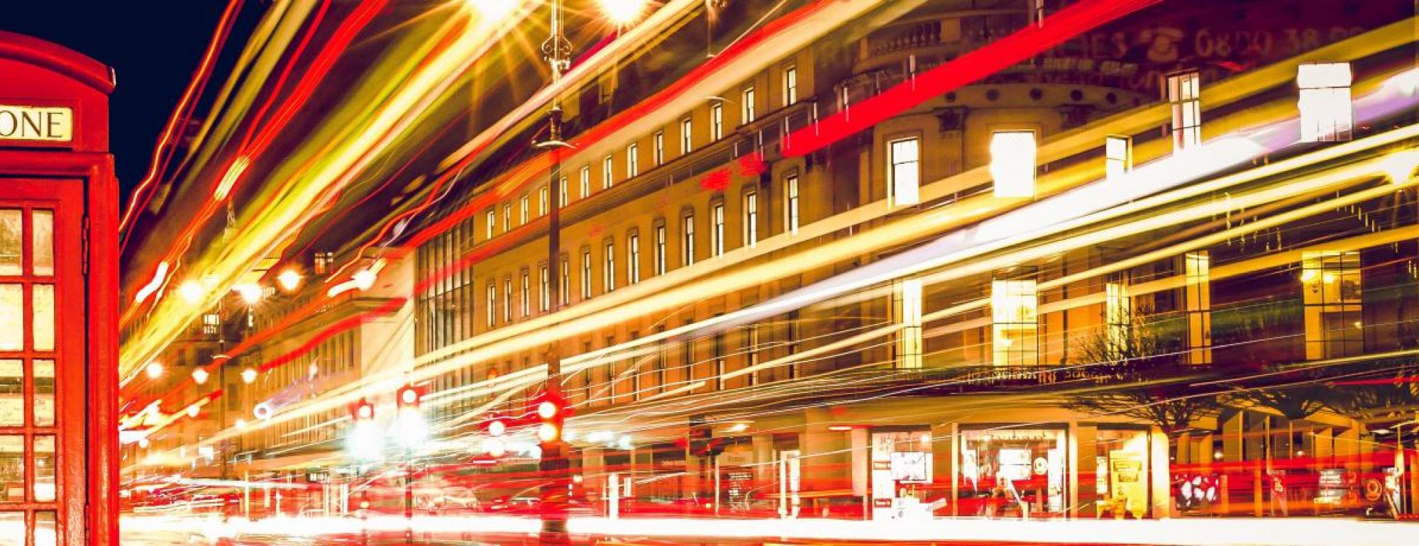 red telephone booth in city at nighttime 