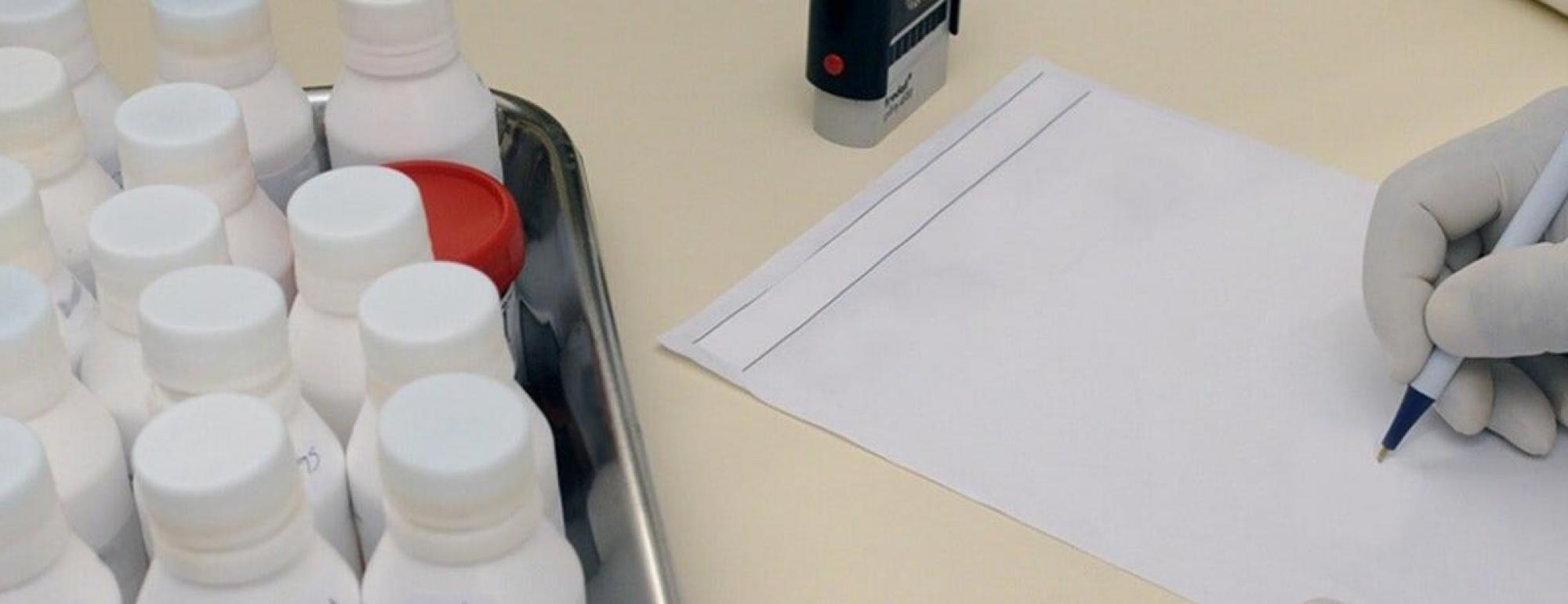 white bottles in a box next to person taking notes