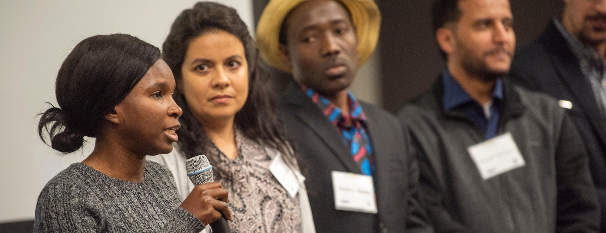 A female student addresses a crowd at the International Center