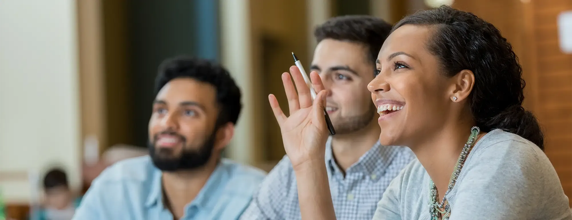 Three students listening attentively to a speaker