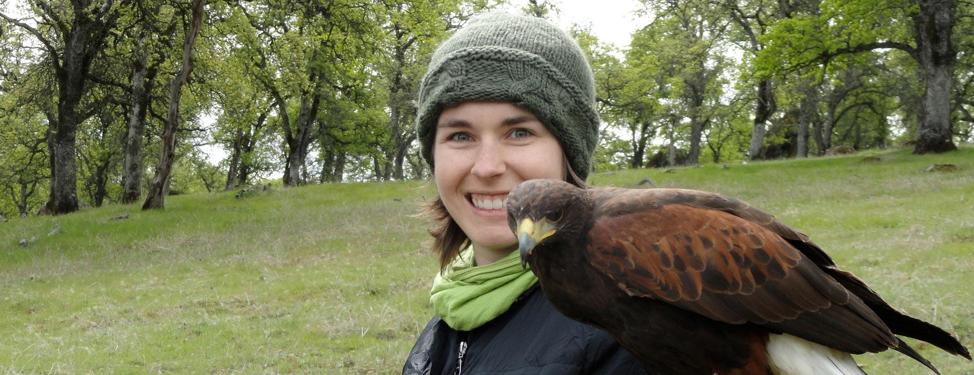 A female student holds a hawk