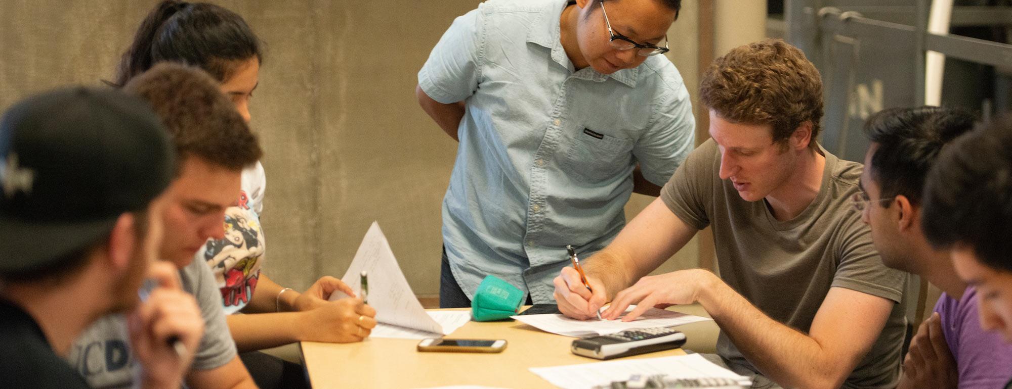 A professor looks over the work of his students