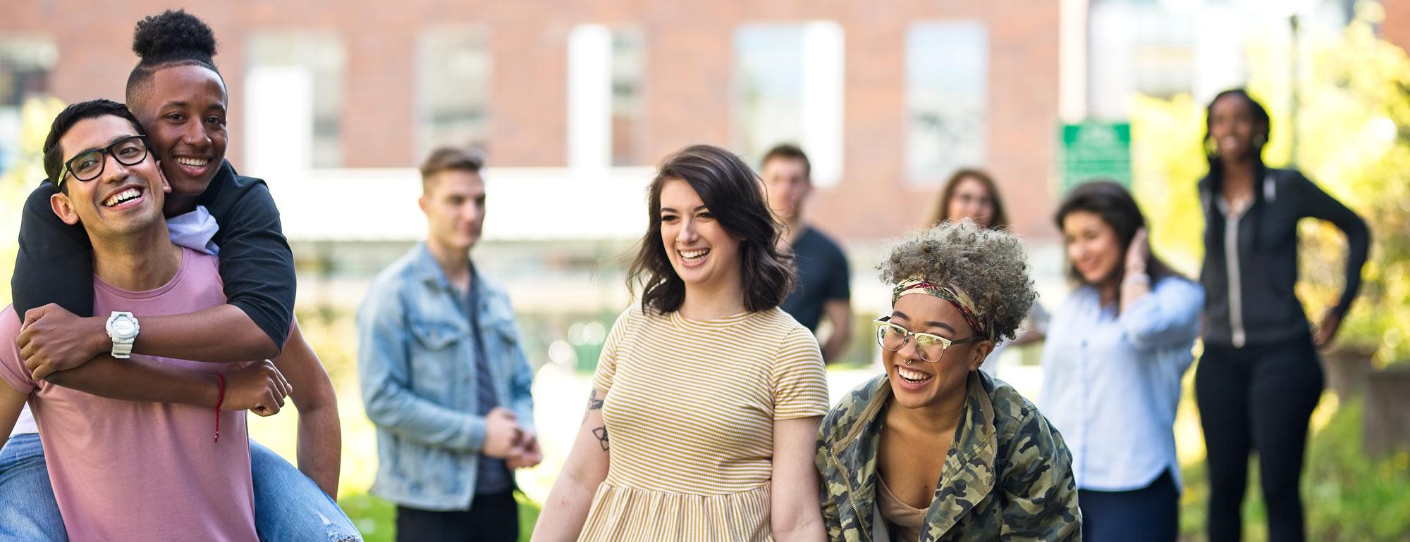 students hanging outside laughing and having fun