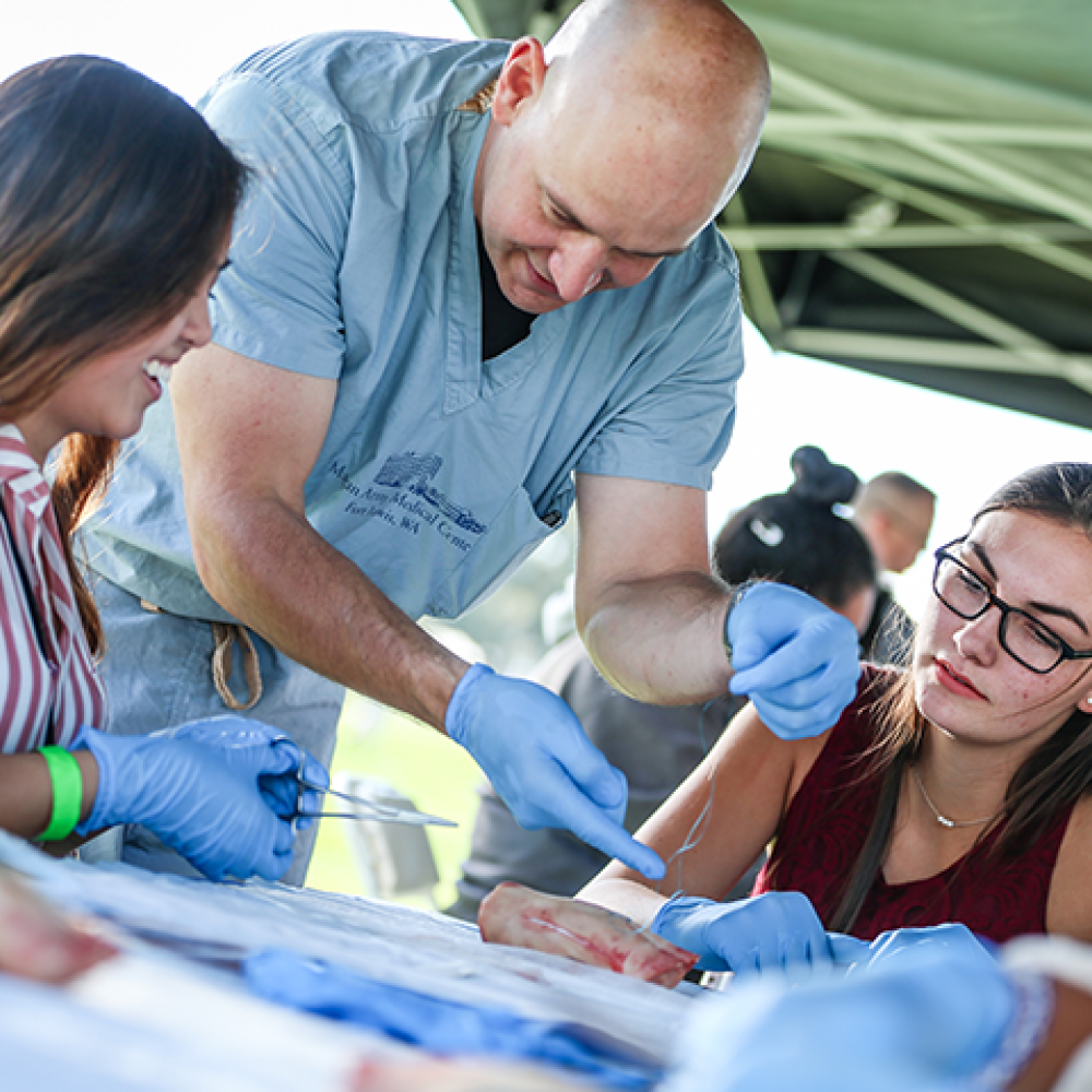 two students observe a teacher demonstrate a surgical technique at UC Davis College of Biological Sciences