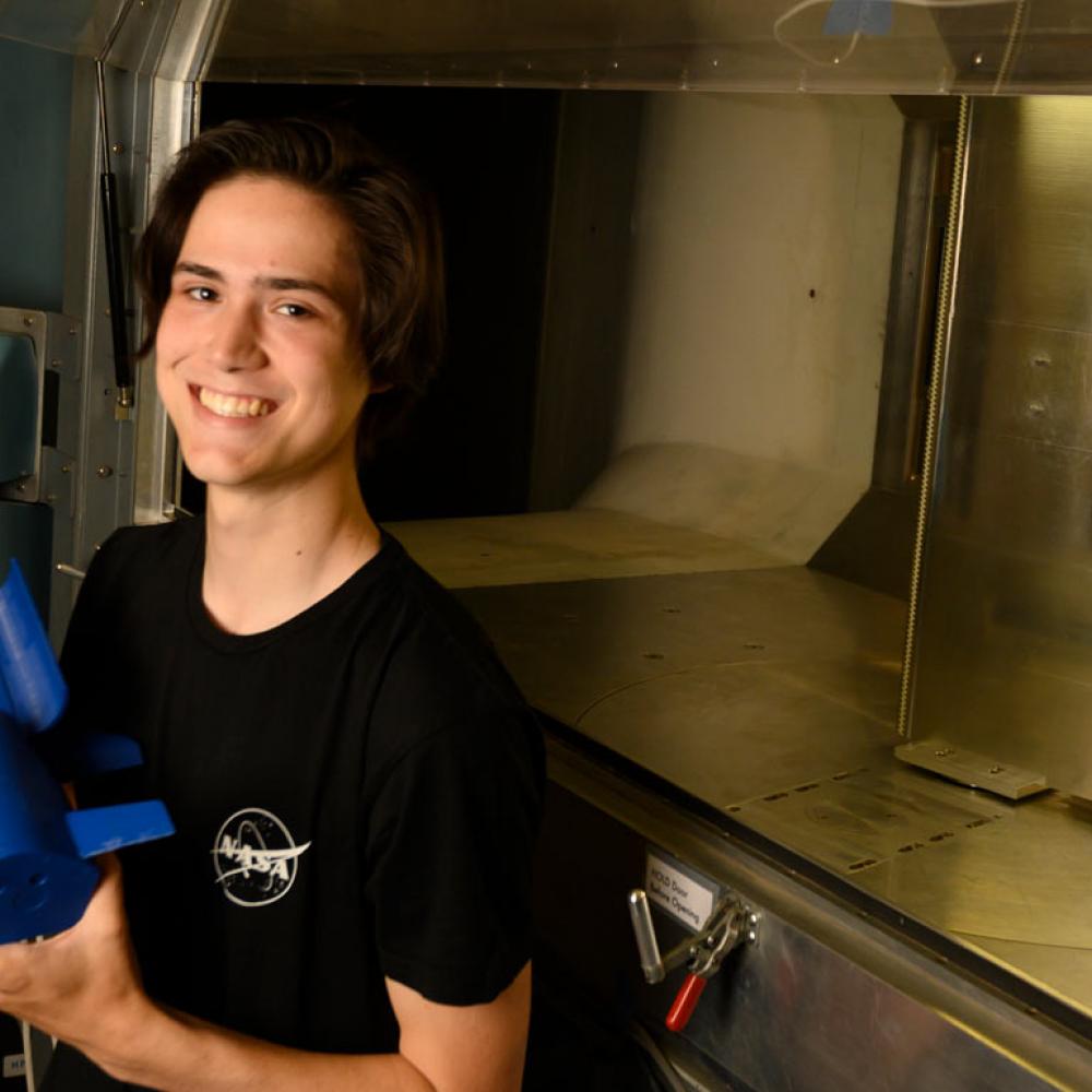 A male student holding a space shuttle model.