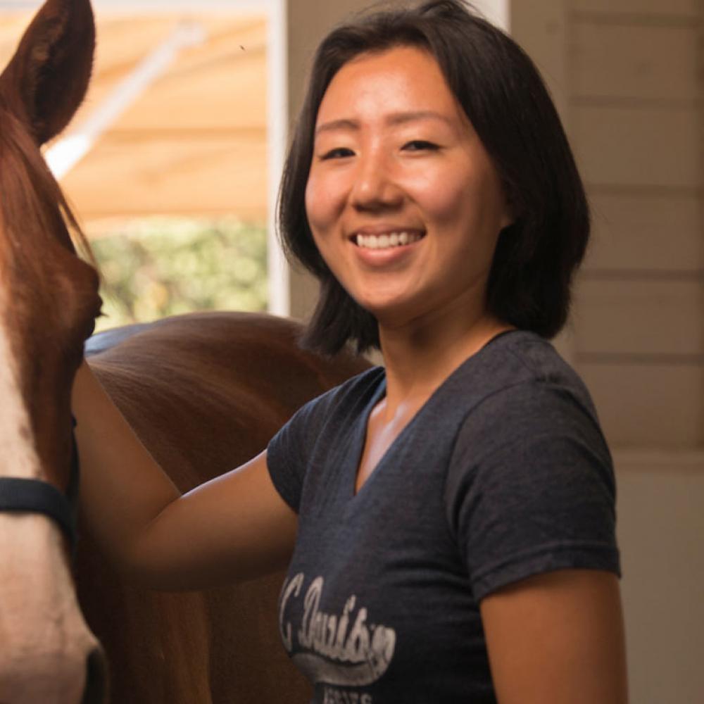 A student pets a horse