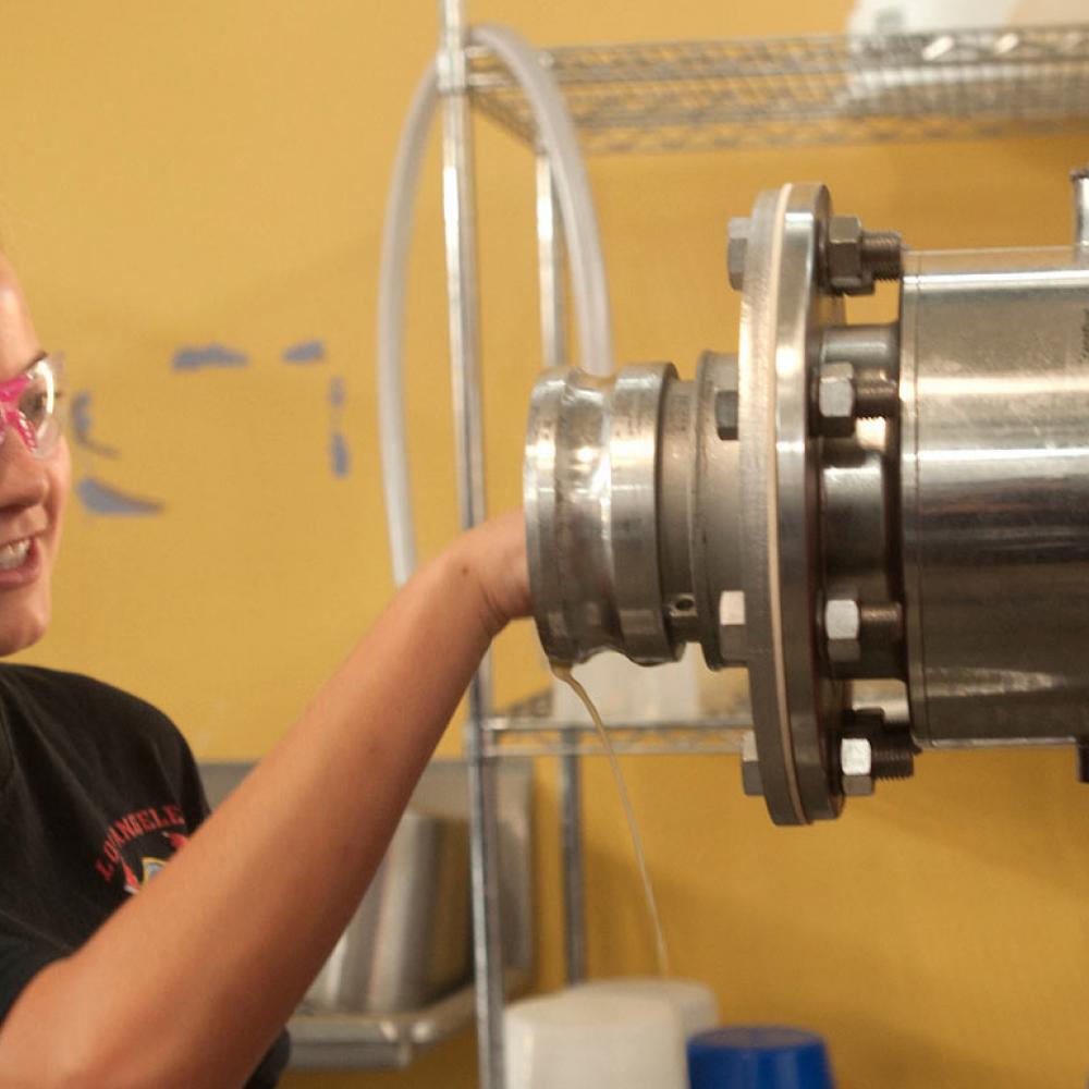 A female student fine tunes some biotech machinery