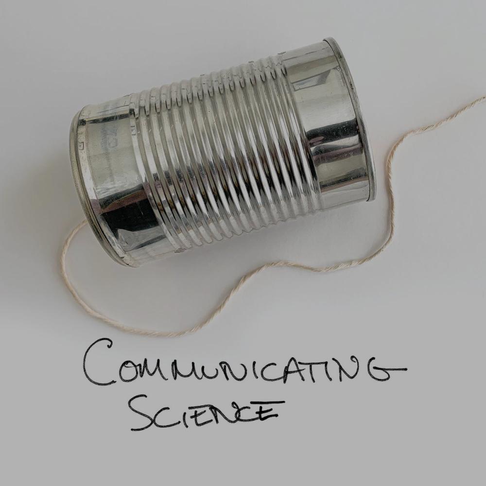 a tin can with a string and the words communication science written on a white background