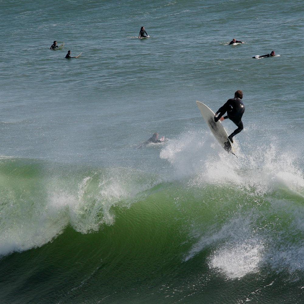 A surver launches himself from a wave in Santa Cruz, ca a short drive from Davis