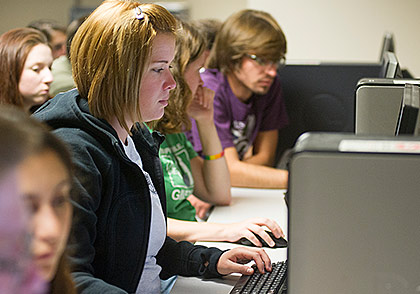 Woman at computer surrounded by others at computer