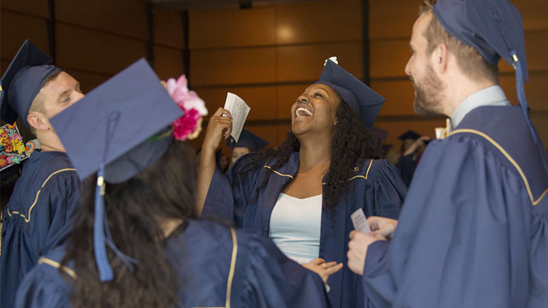 A cluster of graduates laughing