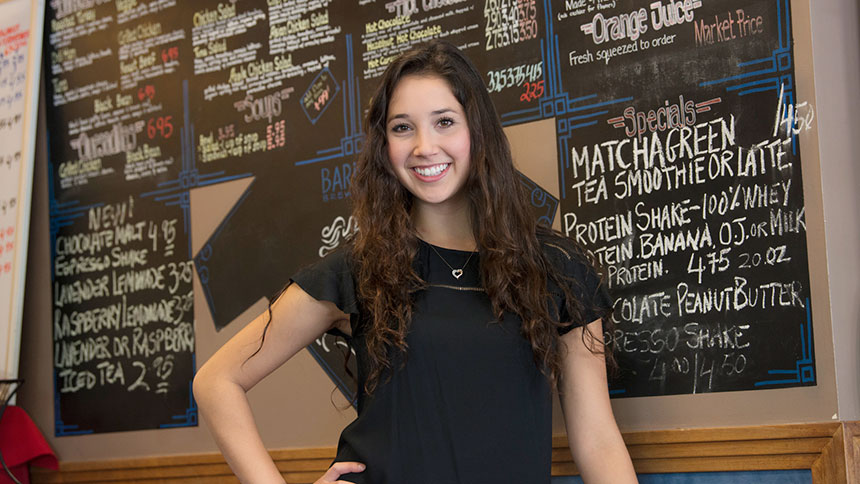 Female student in front of restaurant menu board