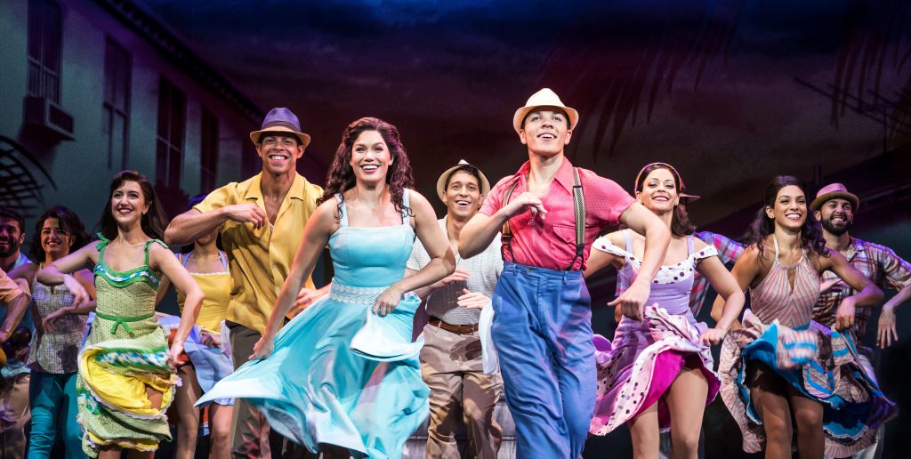 Cast members of On Your Feet dancing on stage.