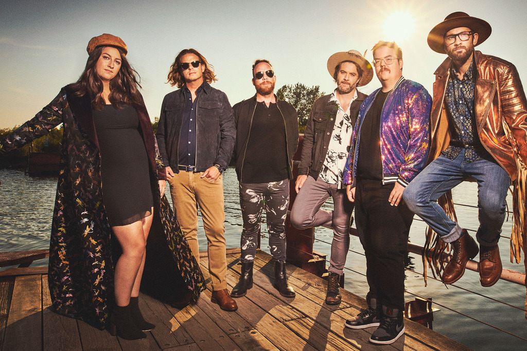 Members of the band standing on a dock.