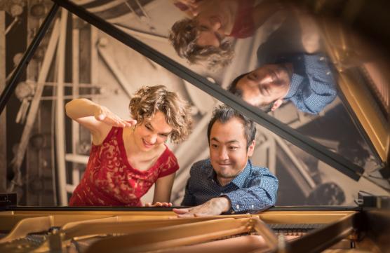 EVA-MARIA ZIMMERMANN and KEISUKE NAKAGOSHIsitting at a grand piano.